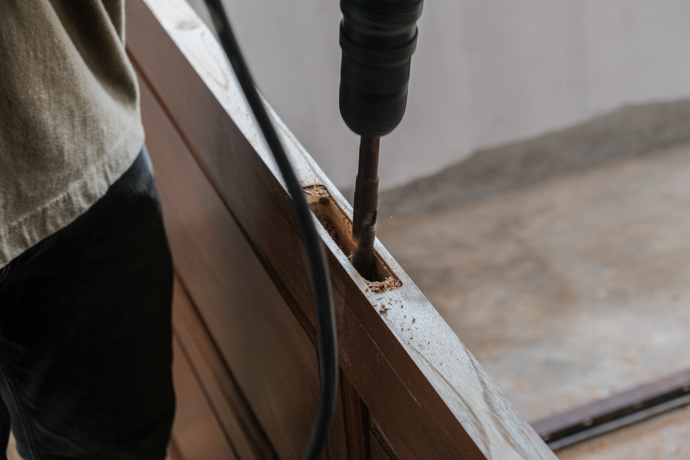 Locksmith installing strike plate on wooden door frame