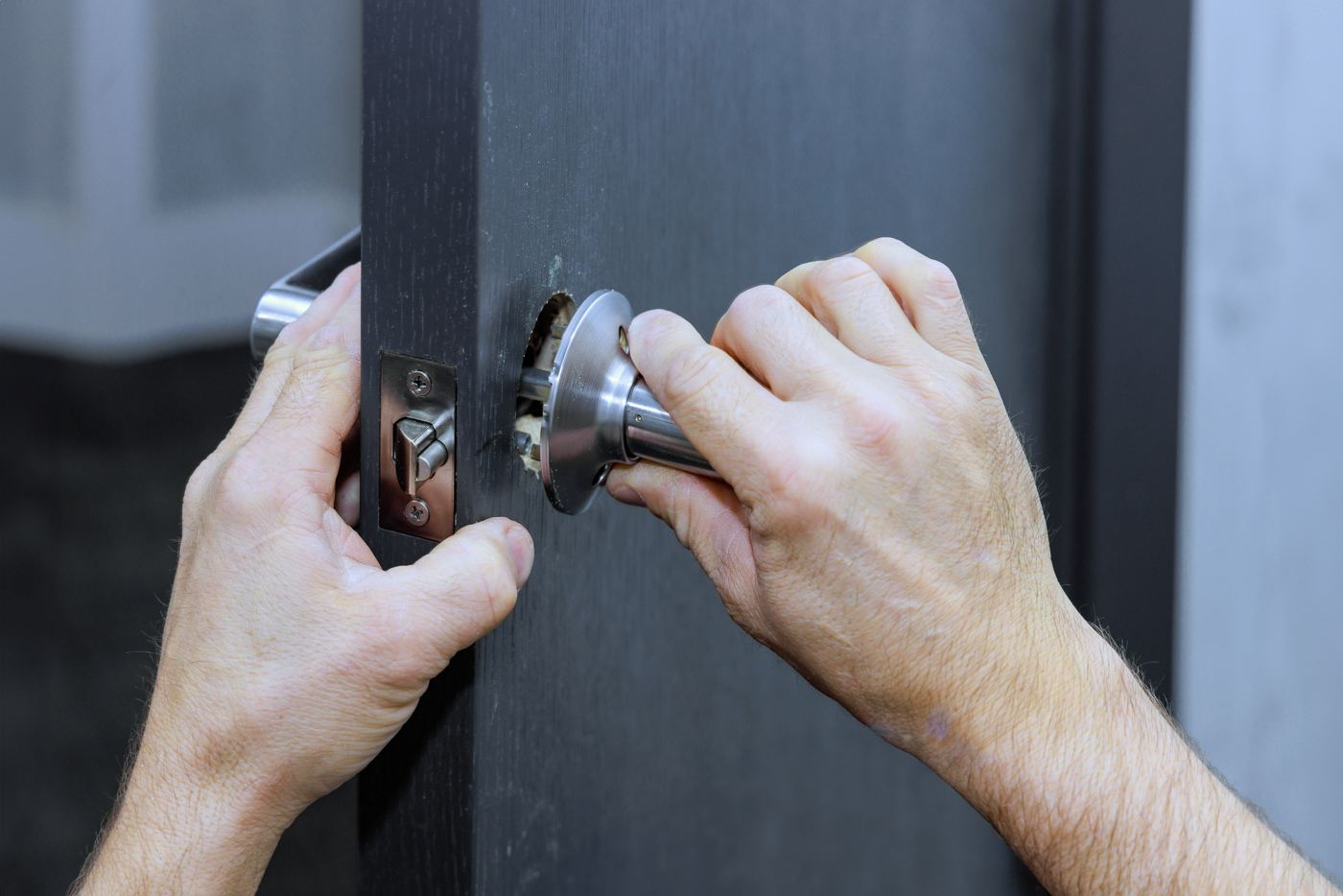Locksmith repairing door lock strike plate securely