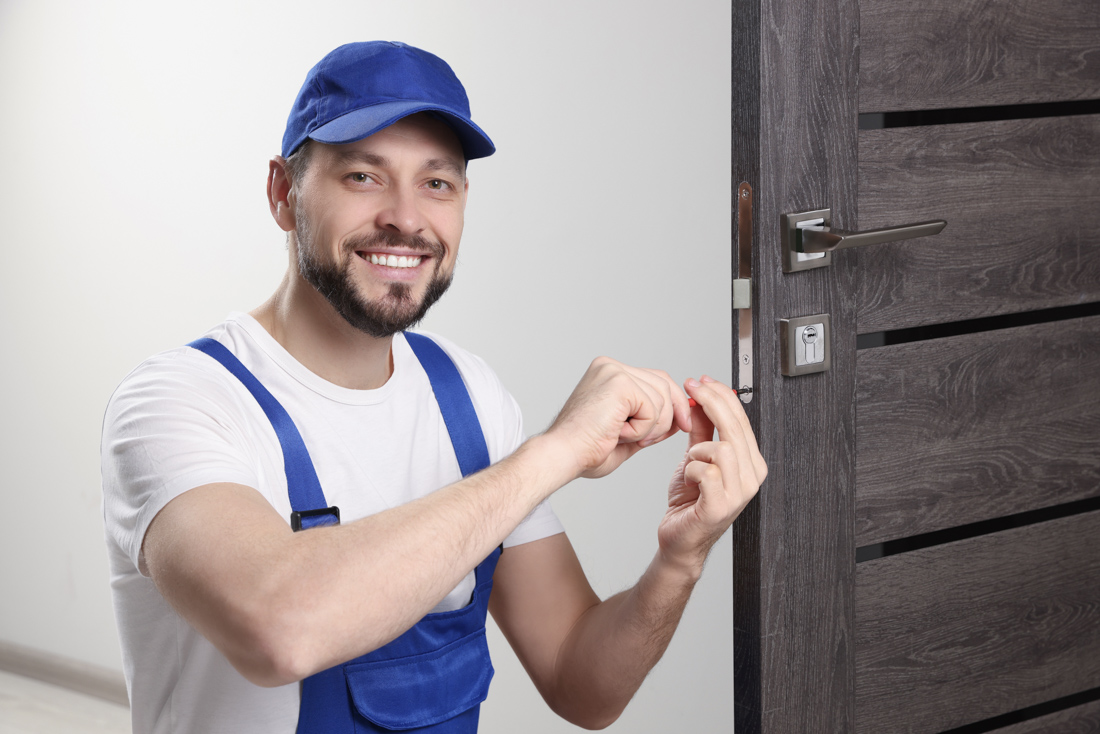Technician painting door for weatherproofing